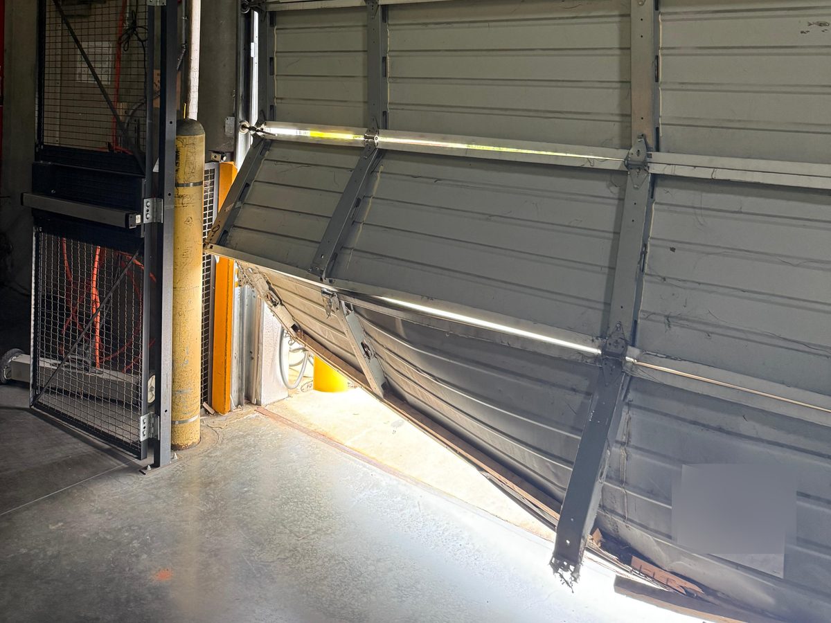 Garage door panels and struts bent at the bottom after an impact – Joy Garage Services job