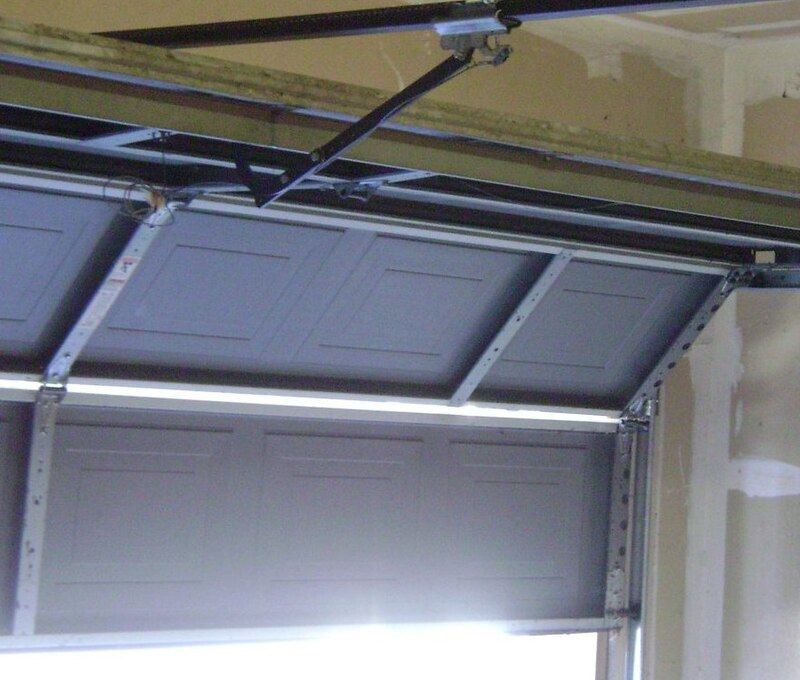 Top of a sectional garage door with its rollers, hinges and curved track