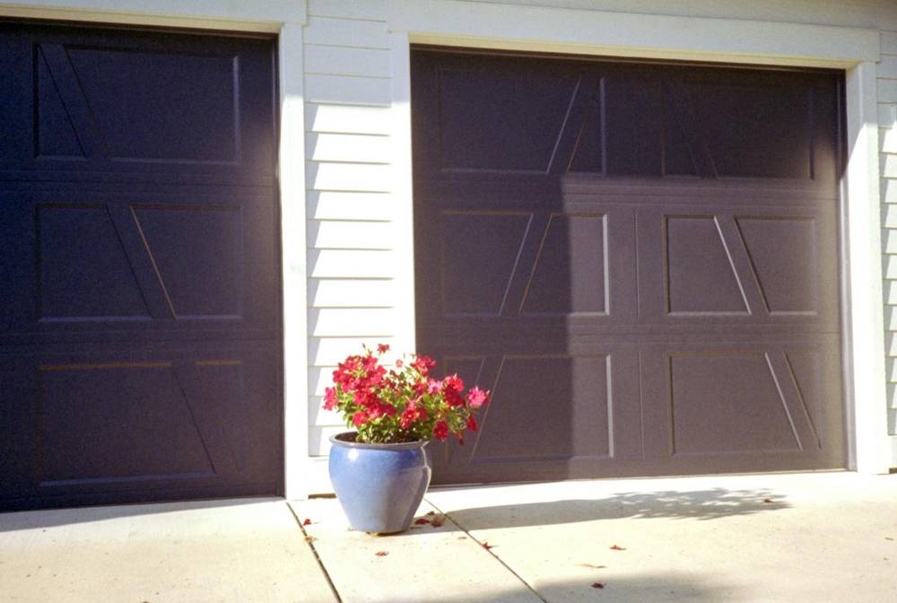 Dark carriage-style garage doors on a white home