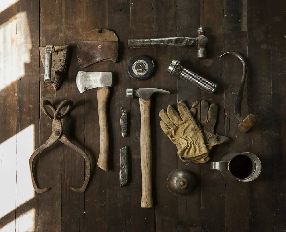 Hand tools laid out on a wooden surface