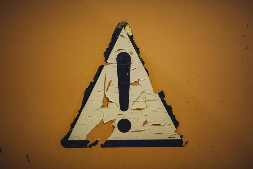 Worn warning sign with an exclamation mark